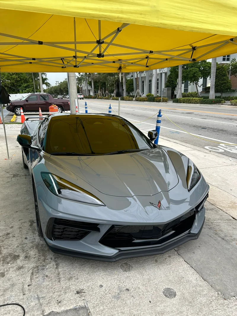 Grey sports car parked under a yellow detailing canopy