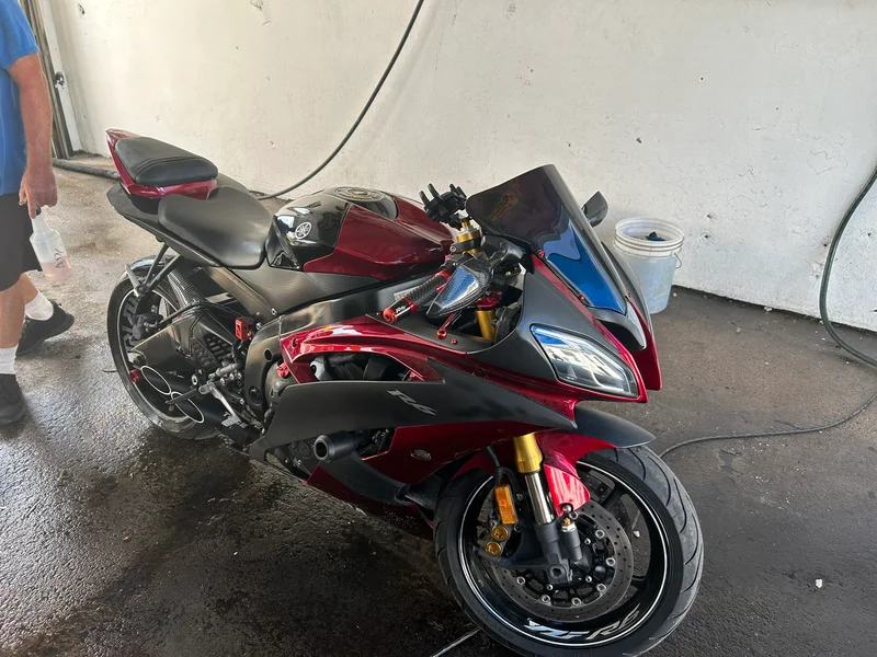 Red sport motorcycle being washed in the bay