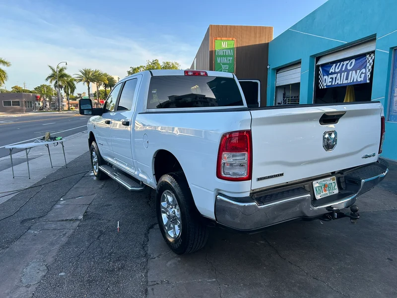 White pickup truck parked beside an auto detailing shop