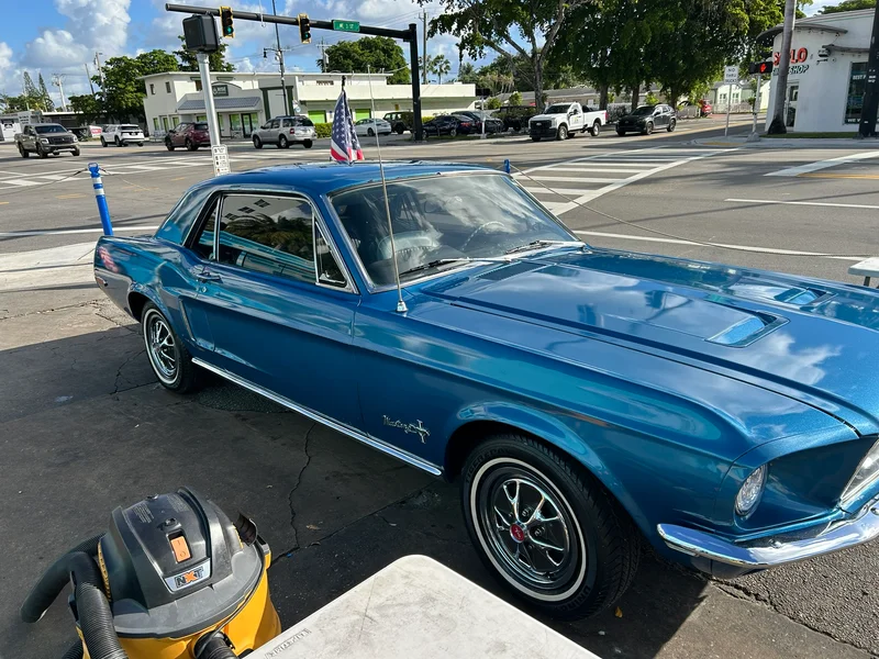 Blue classic coupe being detailed on the street