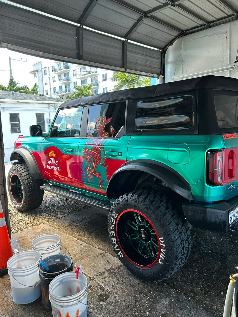 Teal and red off-road SUV being washed