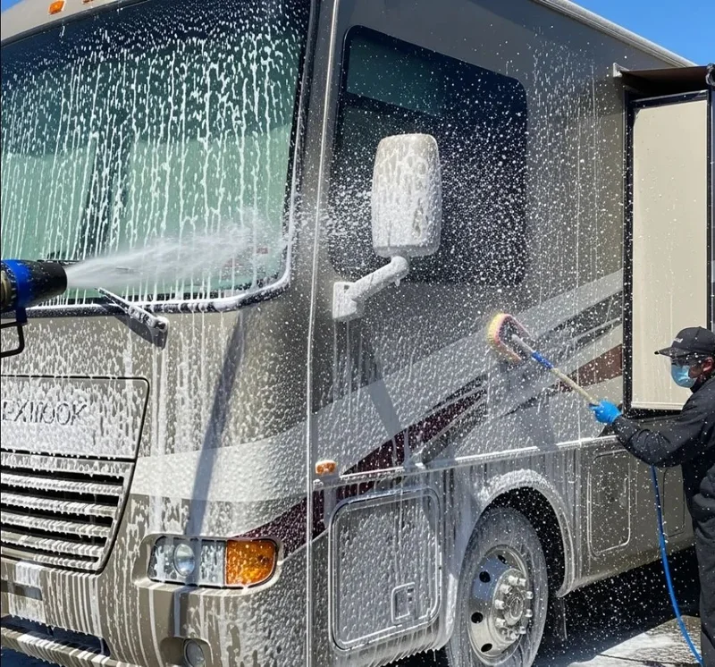 Washing the side of a motorhome with a soft-brush wand