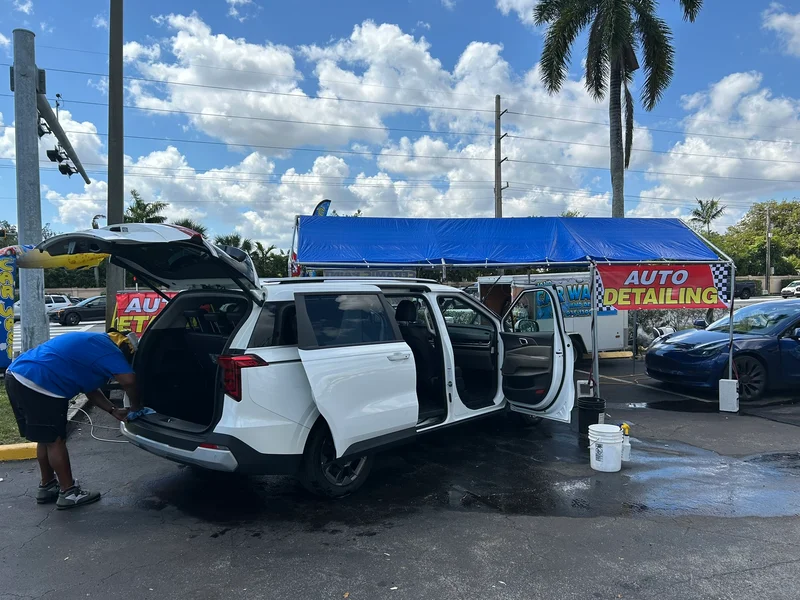 White minivan with doors open during interior cleaning