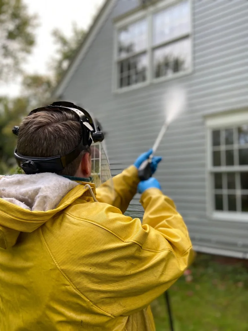 Pressure washing a black boat on a trailer