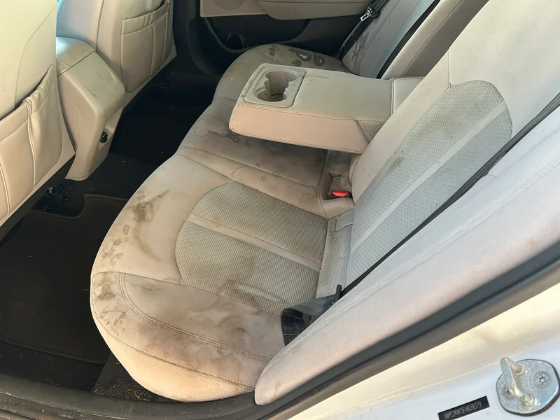 Stained fabric rear seat before interior cleaning