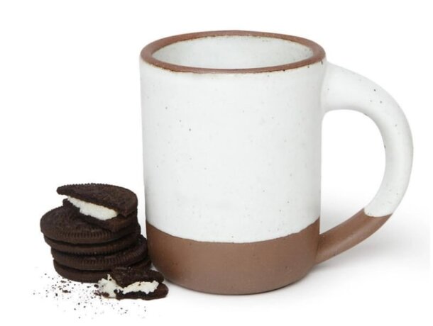 A coffee mug with a stack of cookies beside it, creating a cozy and inviting snack scene.