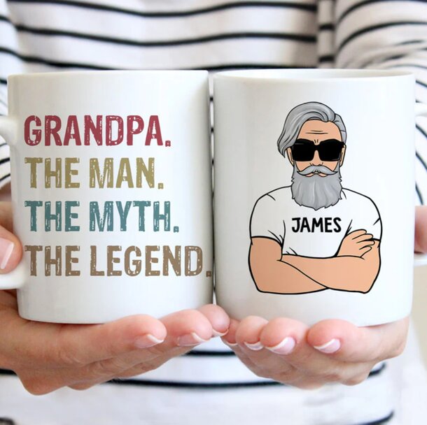 A coffee mug featuring the phrase "Grandpa, the man, the myth, the legend" in bold lettering.