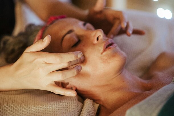A woman receiving a facial massage in a serene spa environment, promoting relaxation and rejuvenation.