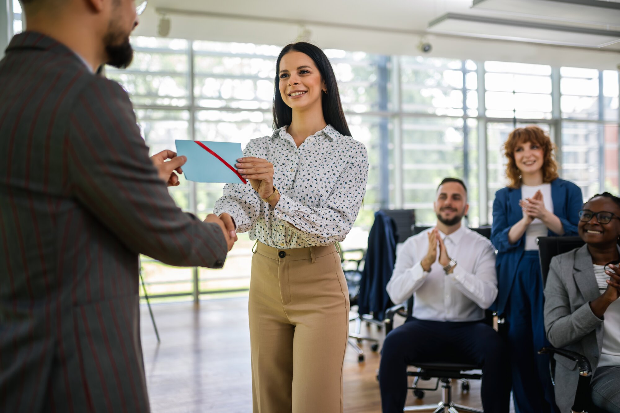 A woman shakes hands with a customer in a restaurant, showcasing a friendly and professional interaction.  