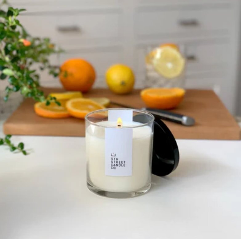 Candle on kitchen counter with citrus fruits