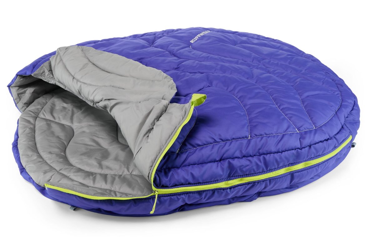 A cozy dog bed featuring a blue and green quilt design, providing a comfortable resting place for pets.
