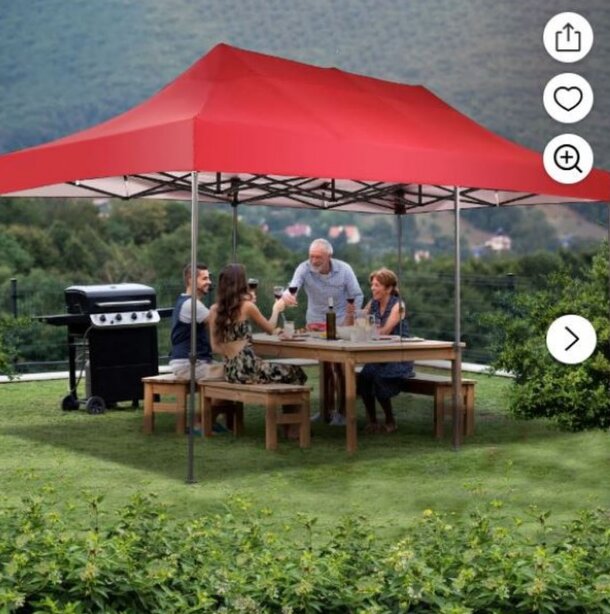 A family sitting together beneath a red canopy tent, sharing a moment in a sunny outdoor setting.