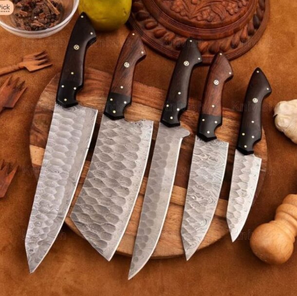 A wooden cutting board displays five different knives, highlighting their unique designs and sharp blades.