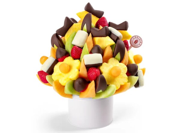 A colorful bouquet of assorted fruits elegantly arranged in a clear vase.