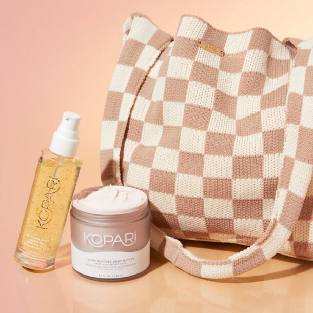 A bag filled with various skincare products next to a stylish purse on a flat surface.