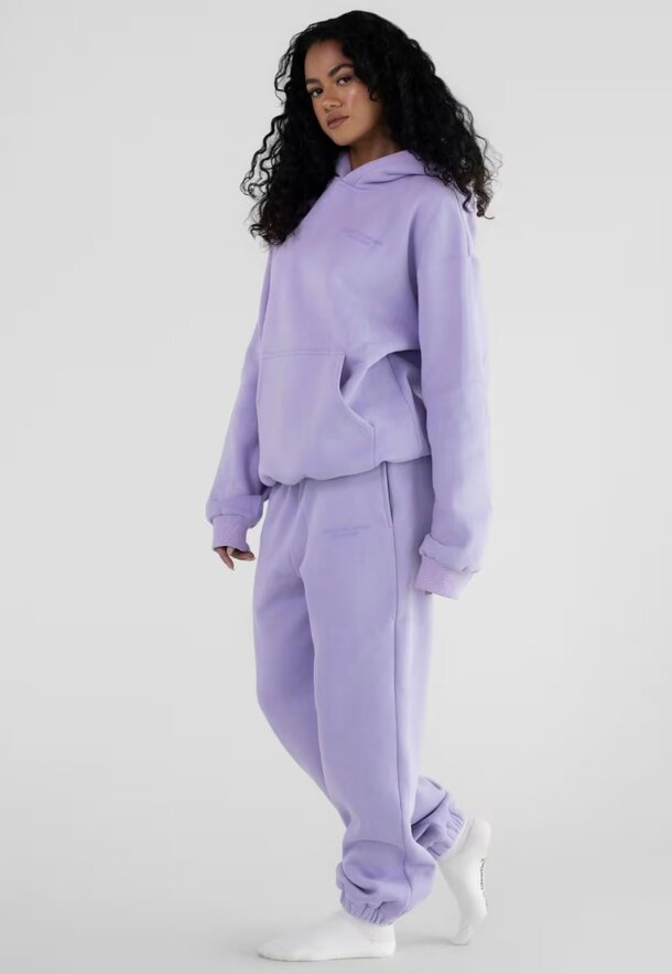 A purple sweatshirt and matching sweatpants set displayed together on a neutral background.