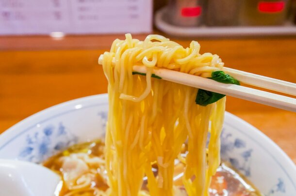 A bowl of noodles with chopsticks resting on the side, showcasing a delicious Asian dish.