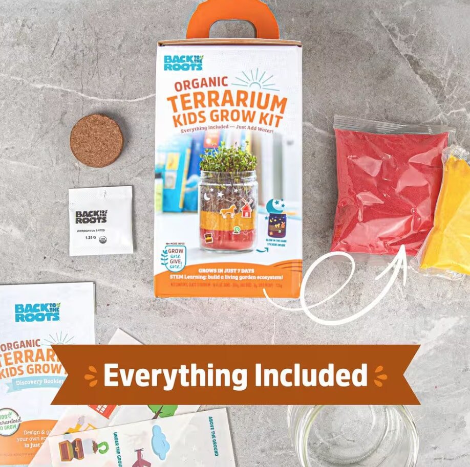 Organic Terrarium Kids Grow Kit on a gray surface, includes soil pellet, seeds, colored sand bags, instruction booklet, and box with vibrant imagery.