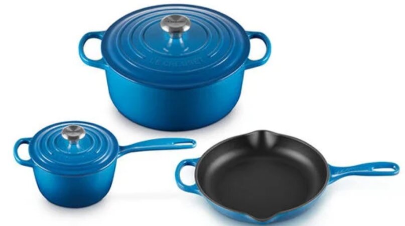A set of three blue cookware pieces, including a Dutch oven, saucepan, and skillet, with silver knobs. The sleek design suggests quality and functionality.