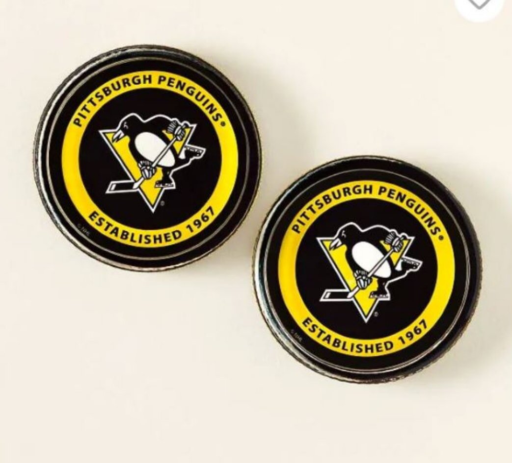 A collection of Pittsburgh Penguins pin badges featuring the team's logo and colors.