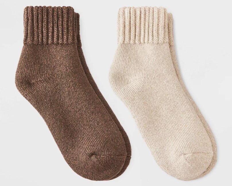 Two pairs of socks displayed, one brown and one white, arranged neatly side by side on a light background.