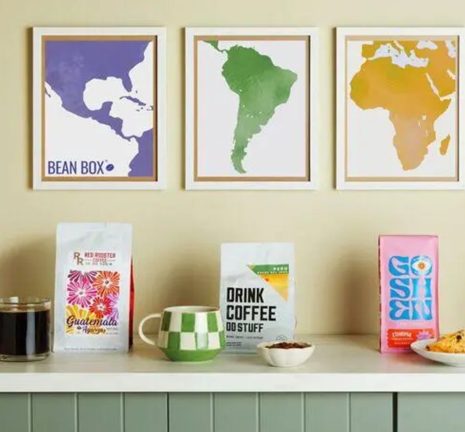 Three framed world maps are arranged on a counter, showcasing different geographical details and artistic styles.