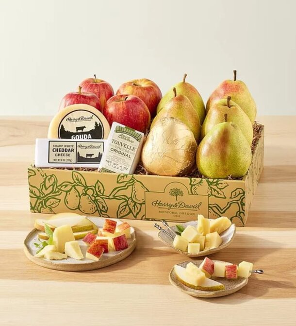 A plate featuring apple and pear slices alongside cheese and assorted crackers.