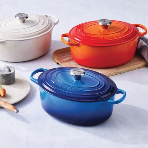 Le Creuset signature enameled cast iron Dutch oven in vibrant orange, showcasing its iconic design and durable construction.