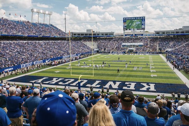 Aerial view of Kentucky football stadium filled with fans during a game, showcasing vibrant team colors and excitement.