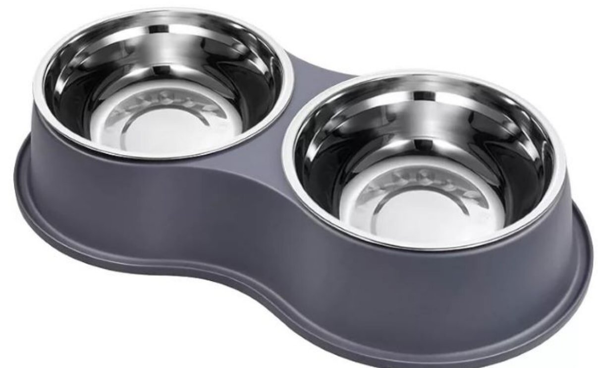 A sleek, modern pet feeding station with two shiny metal bowls set in a curved, gray base. The design is simple and functional, ideal for cats or small dogs.