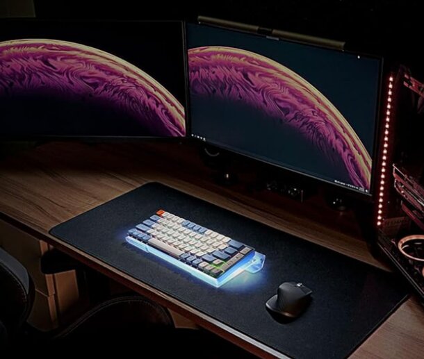 A computer desk featuring two monitors and a keyboard, arranged for a dual-screen workspace setup.