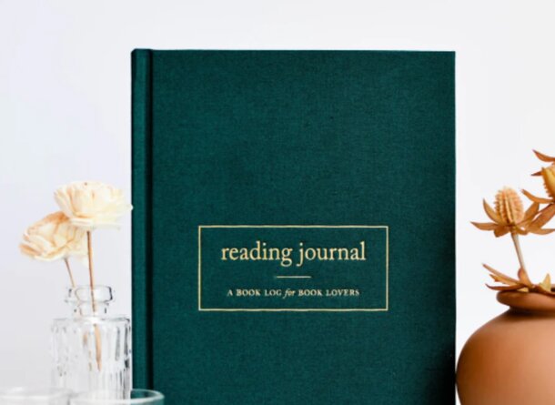 A green reading journal with a textured cover, open to a page filled with handwritten notes and reflections.