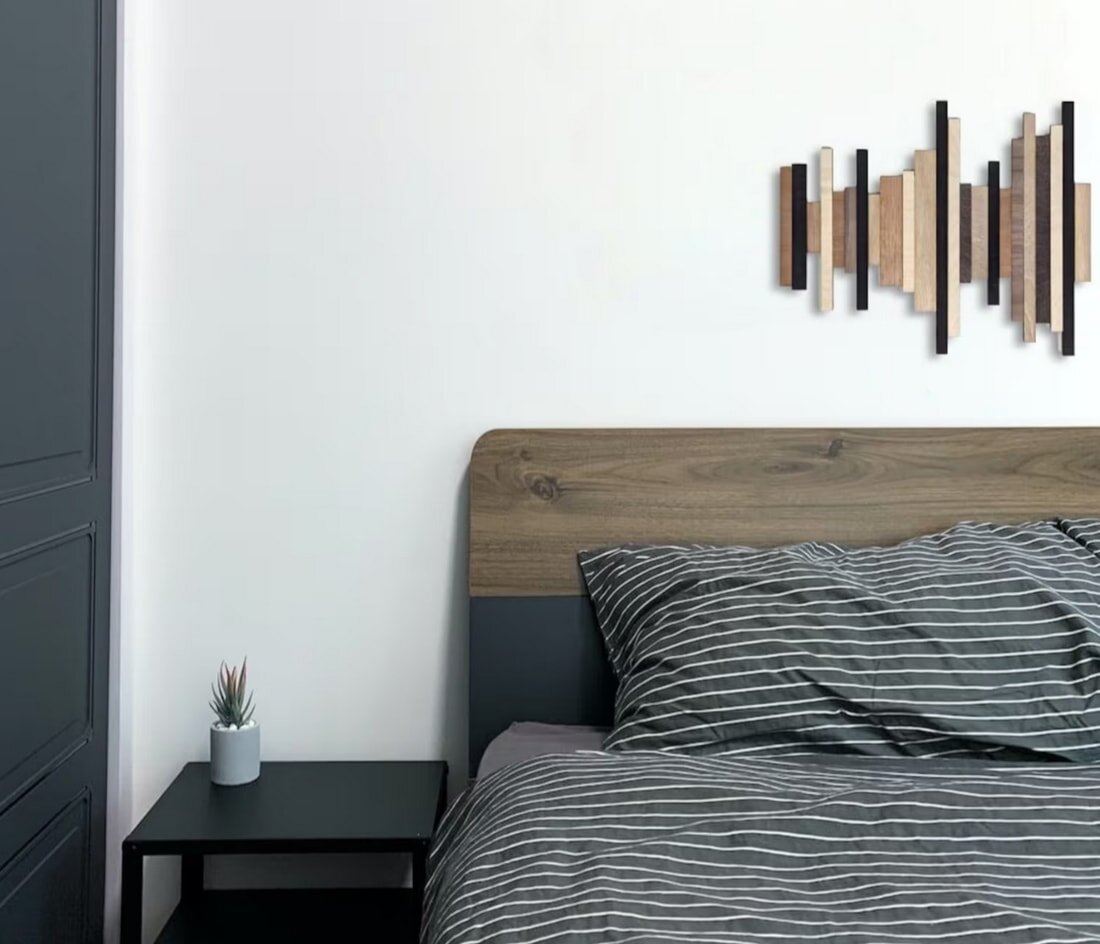 A cozy bedroom featuring a neatly made bed and a stylish nightstand beside it.