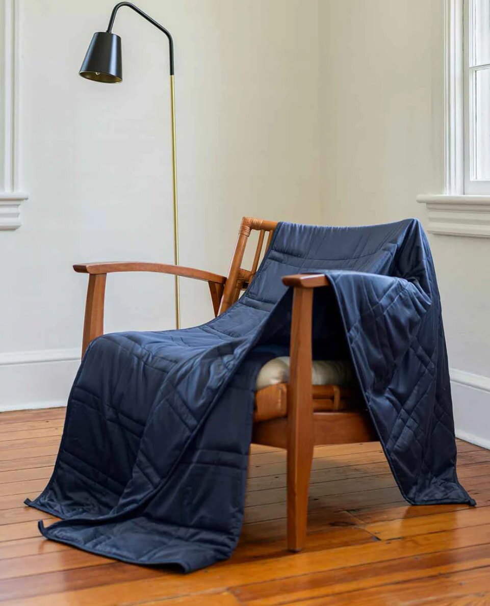 A chair adorned with a blanket, set in a comfortable room environment.