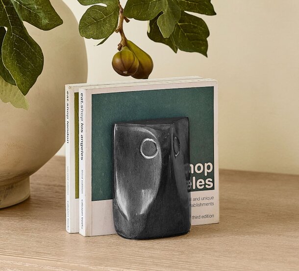 A book resting on a table beside a green plant, creating a cozy reading atmosphere.