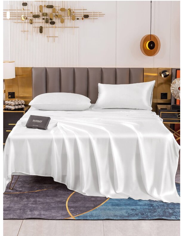 A neatly made white bed featuring a white sheet and a matching pillow, creating a clean and serene sleeping environment.