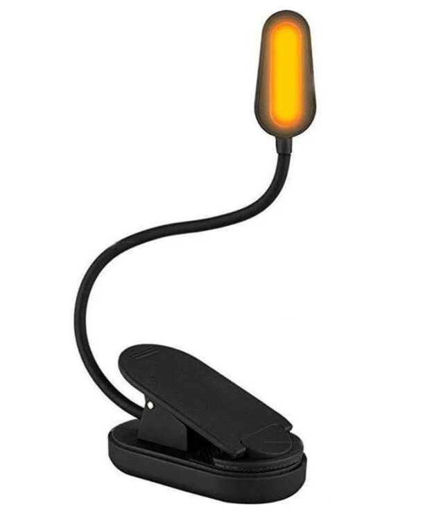 A black and yellow light illuminates a desk lamp, casting a warm glow across the workspace.