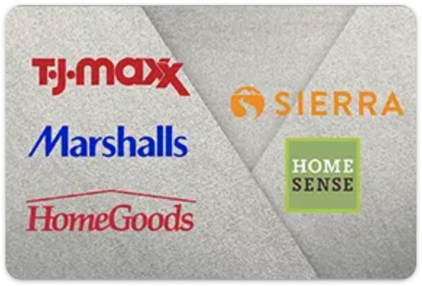 Two stuffed animals perched on a potted plant, surrounded by green leaves and soft sunlight.