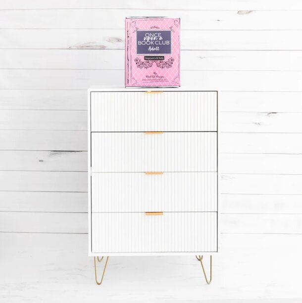 A white dresser with a pink box placed on top, showcasing a simple and elegant home decor arrangement.