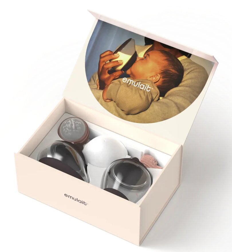 An open box labeled "emulait" contains feeding accessories. The box lid features a serene image of a baby being bottle-fed, emphasizing care and nourishment.