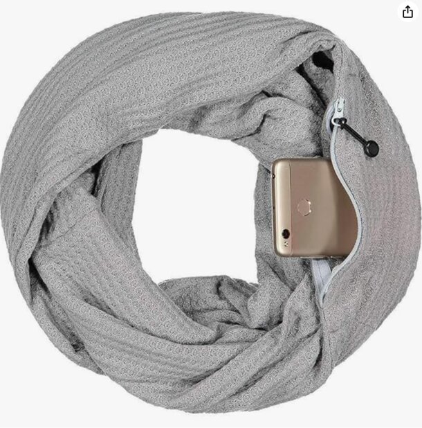 A gray scarf draped with a cell phone nestled within its folds.
