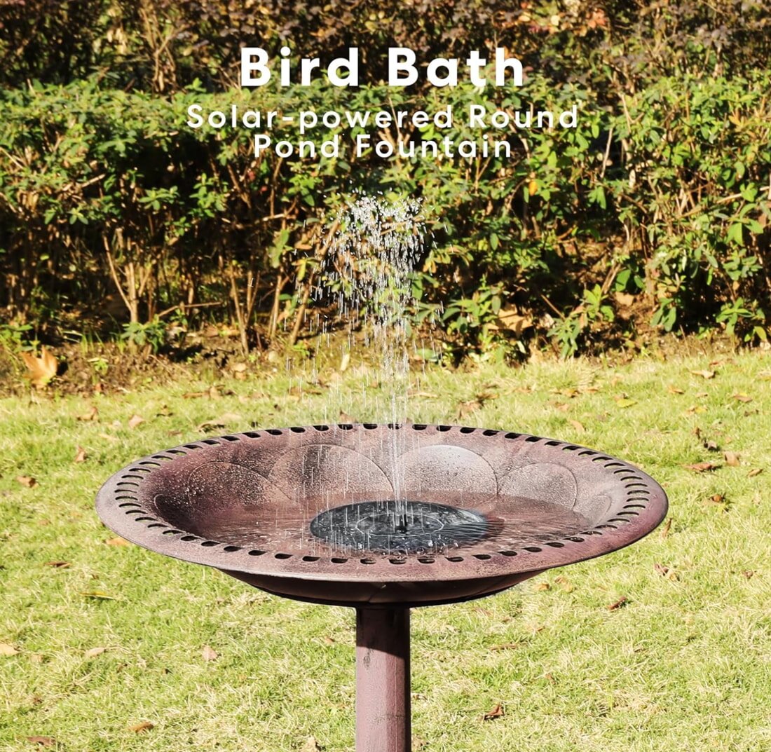 A decorative bird bath with water cascading from the top, set in a garden environment.