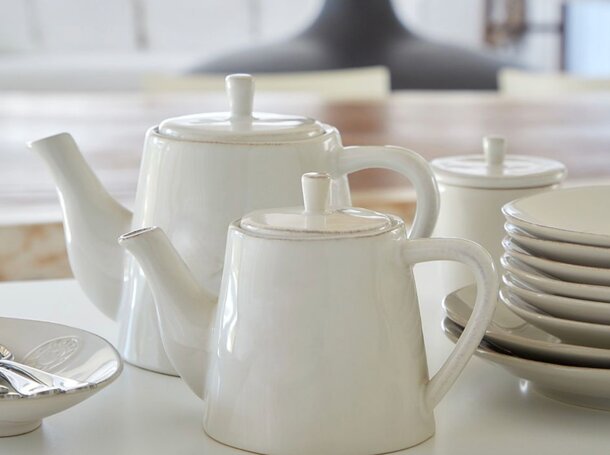 A simple white table with a smooth surface, positioned in a well-lit room.