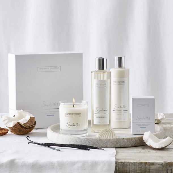 Coconut and vanilla gift set featuring a candle, coconut oil, and a bottle of coconut oil in elegant packaging.