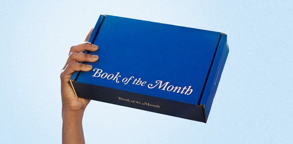 A book displayed prominently with a label indicating it is the book of the month, featuring an attractive cover design.