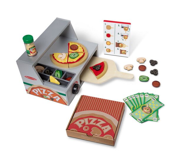 A pizza oven surrounded by various pizza toppings and recipe cards on a countertop.