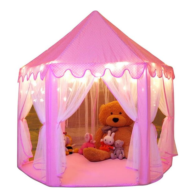A pink tent with a teddy bear sitting inside, creating a cozy and playful atmosphere.