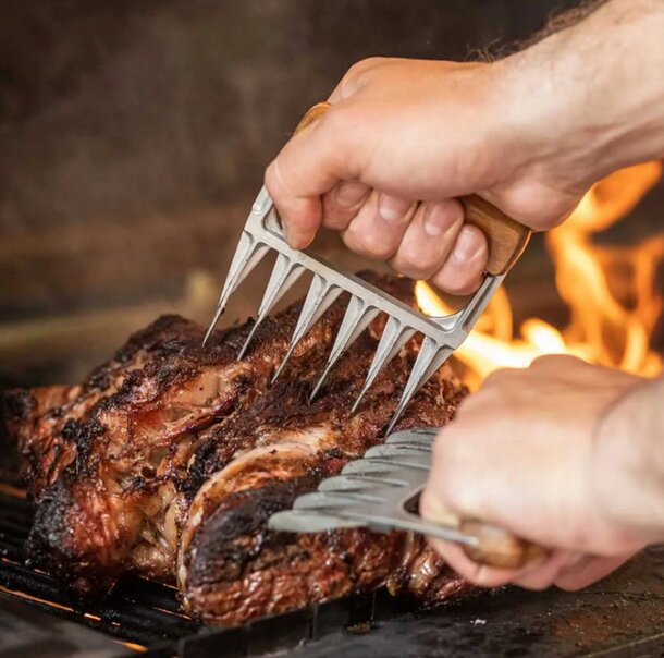 A person is using a manual meat grinder to chop meat into finer pieces for a recipe or meal preparation.