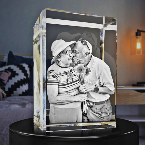 A couple shares a kiss, captured in a photo displayed on a crystal block, symbolizing love and intimacy.