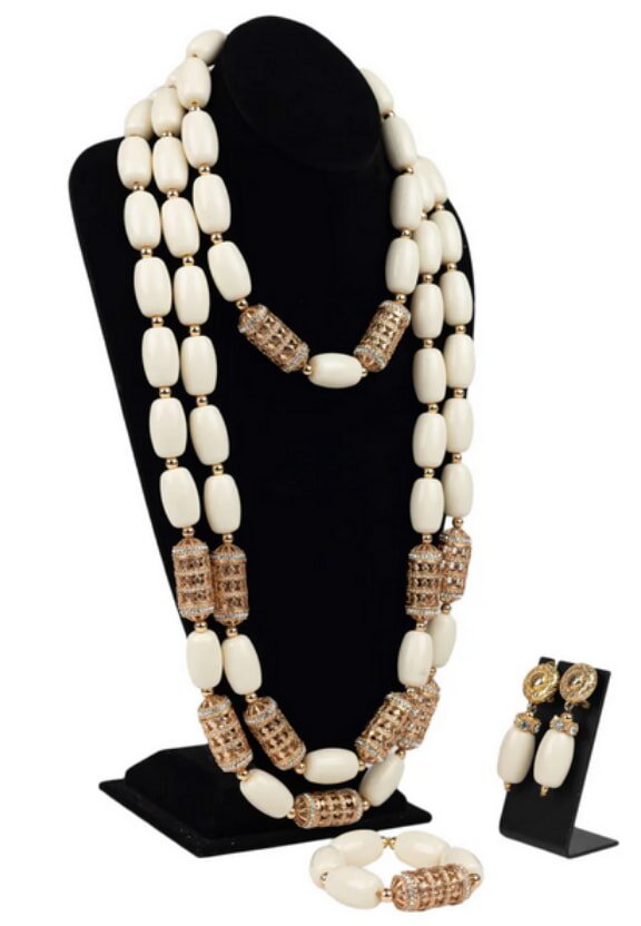 A white necklace and matching earrings set displayed elegantly on a soft background